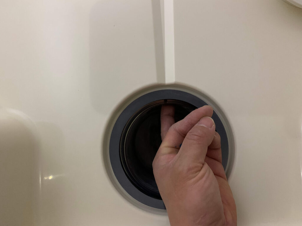 洗濯機防水パン本体と接続時に洗濯トラップを押さえるイメージ